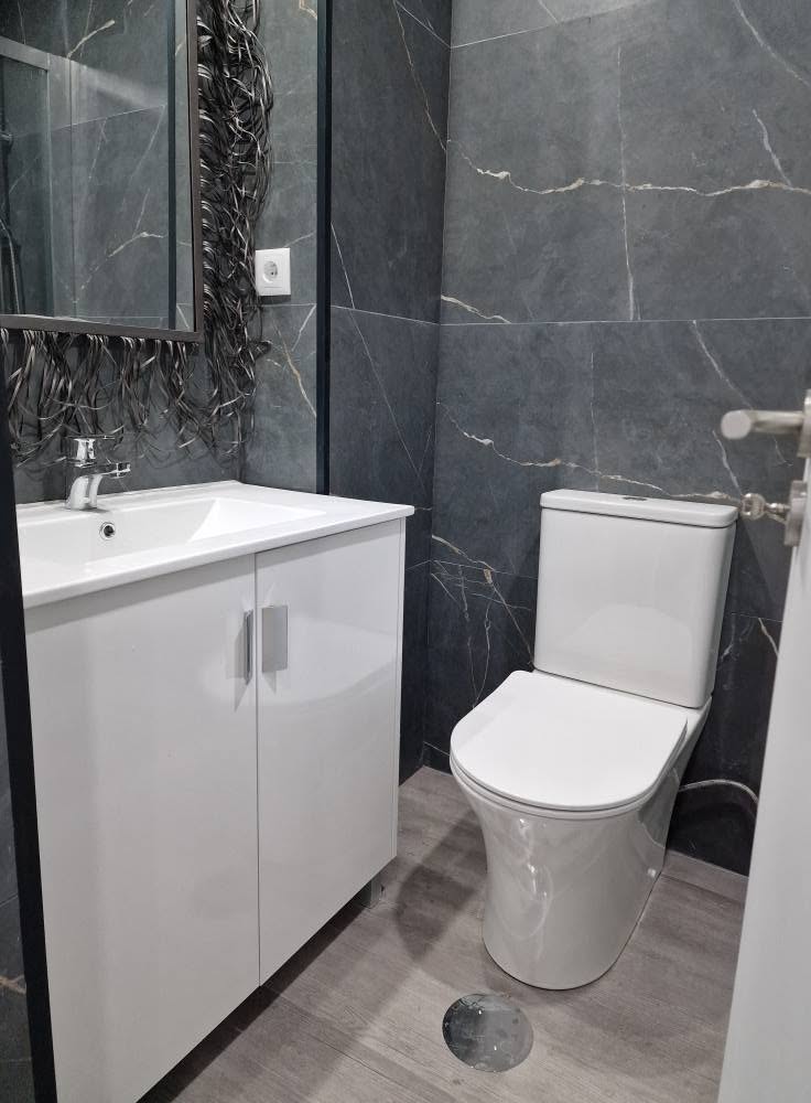 Casa de banho do apartamento T1 depois da remodelação, com móvel lavatório e sanita novos